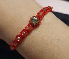 a close up of a person wearing a red bracelet