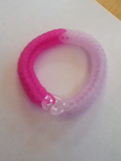 a pink bracelet sitting on top of a piece of paper