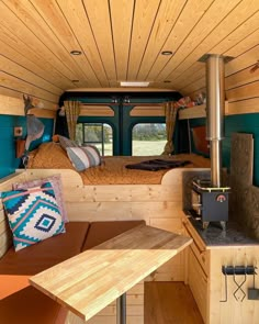 the interior of a camper with wood paneling and blue walls, including a bed