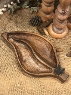 a wooden spoon sitting on top of a table next to pine cones and other decorations