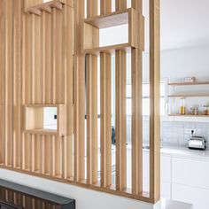 a kitchen with wooden cabinets and white counter tops, along with open shelving on the wall