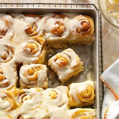 a pan filled with cinnamon rolls covered in icing