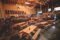 the inside of a building with many tables and benches