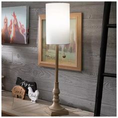 a lamp on a table next to two pictures