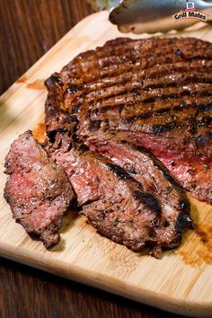 the steak is ready to be served on the wooden cutting board next to the salad