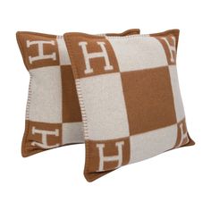 two brown and white checkered pillows with the letter h on each one side,