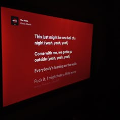 a red screen with words on it in the dark