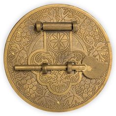 an ornately designed brass plate with two keys on the front, and one key in the back