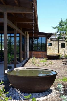 a large bowl shaped fountain in front of a building