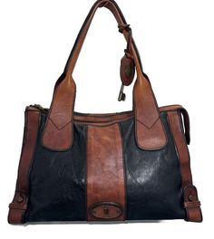 This Fossil Reissue Weekender shoulder bag is a stylish and versatile accessory suitable for various occasions. The bag is made of black/brown leather and features a rectangular shape with a zip closure and gold color hardware. It has a medium/large size, measuring 15 inches in width, 10 inches in height, and 4 inches in depth, and comes with a 9-inch shoulder strap made of matching leather. The bag has a solid pattern and is designed with nature, designer, travel, countries, bohemian, and classic themes in mind. It has bottom studs, inner pockets, and rivets, making it a durable and practical choice for everyday use. The bag also comes with a bag charm accessory and has a signature key logo black fabric lining. This Fossil Reissue Weekender shoulder bag is a must-have for anyone looking f Travel Countries, Key Logo, Brown Leather Satchel, Shoulder Bag Vintage, Functional Accessories, Logo Black, Classic Theme, Bag Vintage, In Depth