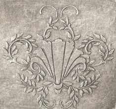 an ornate design on the side of a metal wall hanging ornament, with leaves and scrolls