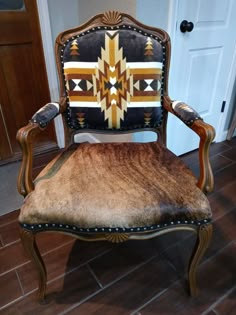 an old fashioned chair with a southwestern design on it's back and seat cushion