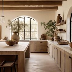 a kitchen filled with lots of counter top space next to a tall vase and potted plant