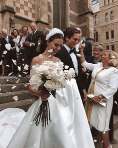 black and white photo of bride and groom walking down the stairs with confetti