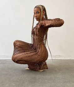 a woman with braids sitting on the ground