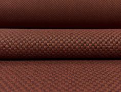 a close up view of the fabric on a couch or chair with brown and black checkerboard pattern