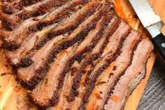 sliced meat sitting on top of a cutting board next to a knife