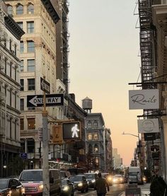 a city street filled with traffic next to tall buildings