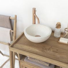 a bathroom sink sitting on top of a wooden table