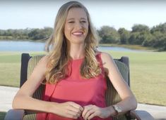 a woman sitting in a chair smiling at the camera