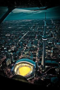 an aerial view of the stadium and surrounding city lights at night, taken from above