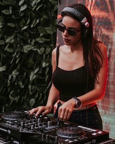 a woman wearing headphones is mixing music