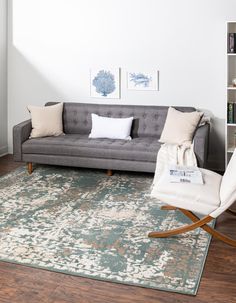 a living room with a couch, chair and bookcase on the floor in front of it