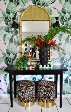 a black table with two stools and a mirror on the wall next to it