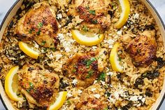 chicken with lemons and rice in a skillet on a marble counter top, ready to be eaten