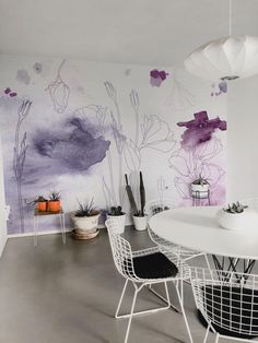 a white table and chairs in front of a painted wall