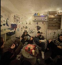 group of people sitting on couches in room with wallpapered walls and ceiling