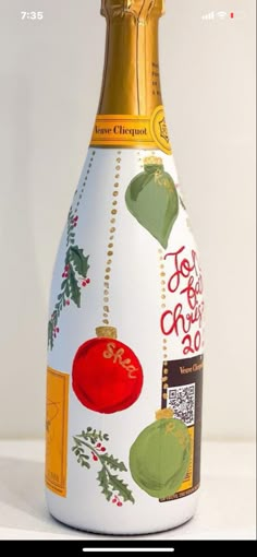 a wine bottle decorated with christmas decorations and gold trimmings is shown in front of a white background