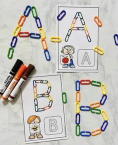 two alphabets with crayons and markers next to them