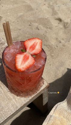 a drink with strawberries is sitting on a wooden table