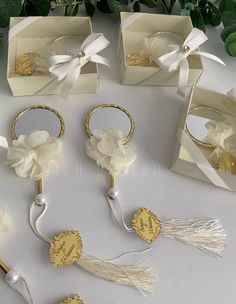 four wedding rings in boxes with ribbons and bows on them, sitting next to each other