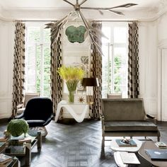 a living room filled with furniture and lots of plants on top of a wooden table