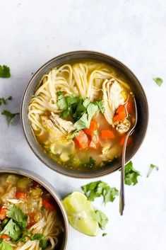 two bowls of chicken noodle soup with cilantro and parsley