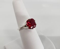 Gorgeous Ruby ring with a lovely 10mm cushion cut Ruby, this ruby is a dark red color with vivid saturation. This ring is absolutely gorgeous and will stun your family and friends! Ruby Ring Silver, Triangle Diamond Ring, Oval Halo Diamond Ring, Star Ruby Ring, Peach Sapphire Engagement Ring, July Birthstone Ring, Raw Diamond Engagement Rings, Green Sapphire Engagement Ring, Blue Opal Ring