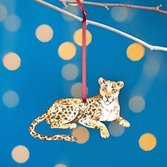 a leopard ornament hanging from a tree branch