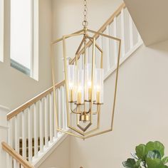 a chandelier hanging from the ceiling over a table in a room with stairs