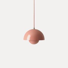 a pink pendant light hanging from a ceiling