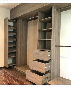 an empty walk in closet with drawers and shelves