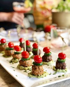 small appetizers are arranged on a plate with tomatoes and cucumber garnishes