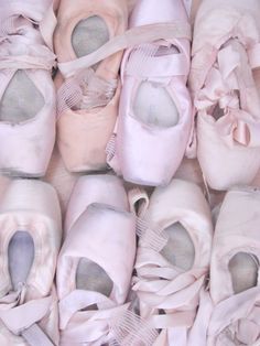 several pairs of ballet shoes are lined up together