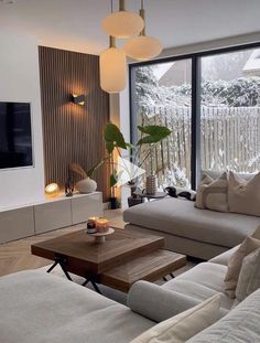 a living room filled with furniture and a flat screen tv mounted on the wall next to a window