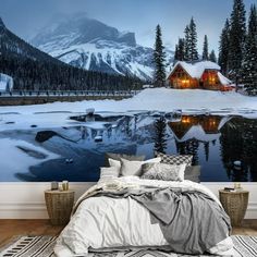 a bed room with a large wall mural next to a night sky and snow covered mountains