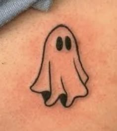 a ghost tattoo on the back of a woman's shoulder