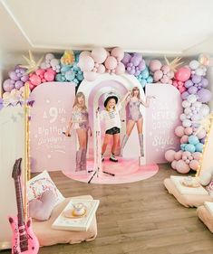 two girls are standing on stage in front of balloons