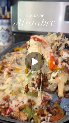 a close up of a pizza on a pan with cheese and vegetables being lifted from it