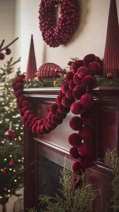 a christmas tree with red decorations and wreaths on the fireplace mantel above it